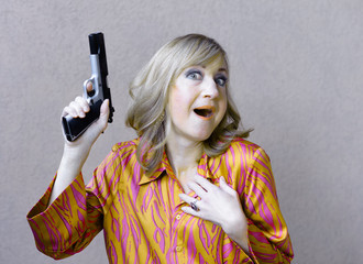 Surprised fashionable woman holds a large loaded gun for self defense. 