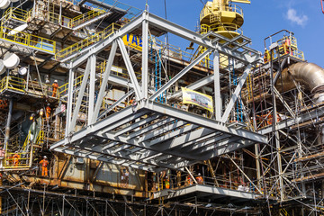 Offshore crane on board a construction work barge performing heavy lifting of a frame strcuture...