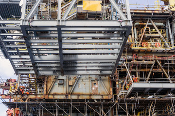A structure frame being lifted by a construction work barge crane to an oil production platform at...