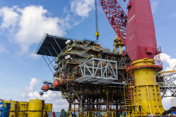 Offshore crane on board a construction work barge performing heavy lifting of a frame strcuture...