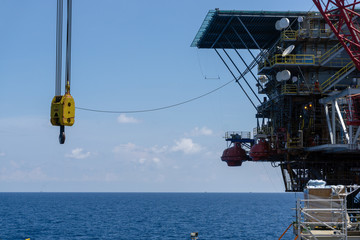 Offshore crane of a construction work barge swing after performing a heavy lifting to an oil production platform at oil field