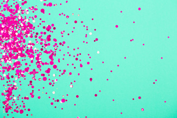 Falling confetti on green pastel background. Holiday and party concept.