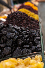 Mix of dried and sun-dried fruits, dried fruits in a wooden box on a white wooden background. View from above. Symbols of the Jewish holiday of Tu B'Shvat