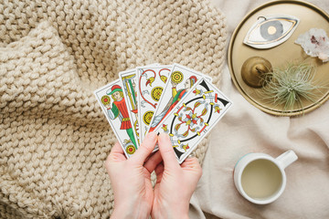 Girls with tarot cards in hands and cup of tea.