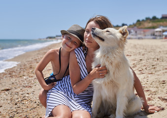 Obraz na płótnie Canvas mother and son with a dog on the beach