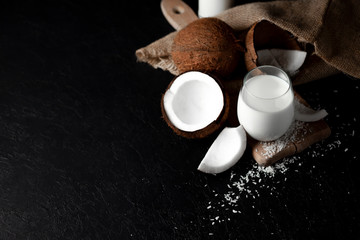 fresh coconut milk in a glass against a dark background, coconut cosmetic cream, milkshake with coconut slices