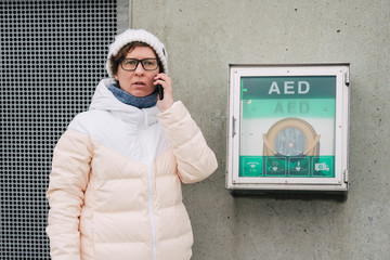 medicine cardiopulmonary resuscitation emergency call. Caucasian woman uses telephone calling 911 help. device box aed automatic defibrillator diseases