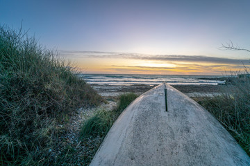 Landscape photo of a boat stranded on the Majorcan beach of Ses Covetes, during sunset with a...