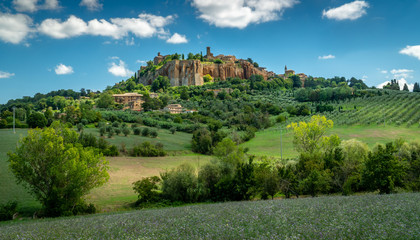 Orvieto, Umbria Italy. Scenic view on ancient city of Orvieto. It is situated on the flat summit of a large butte of volcanic tuff. Surrounded by beautyful meadows with olive and cypress trees.