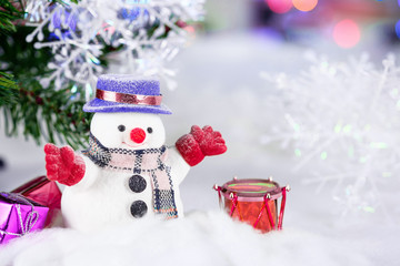 Cute snowman with toy boxes and gifts on a Christmas and winter background.