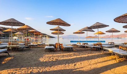 Beautiful beach on the shores of the calm blue bay of the Aegean Sea in the early morning. Beach vacation and holiday destination concept. Bitez, Bodrum, Turkey