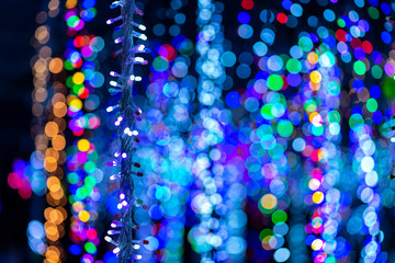 White christmass lights with mulyicolored blurry lights in background