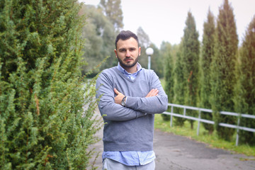 Young guy on the background of European, American city. man in the background of trees and fields and fence. The owner of a beautiful land for business