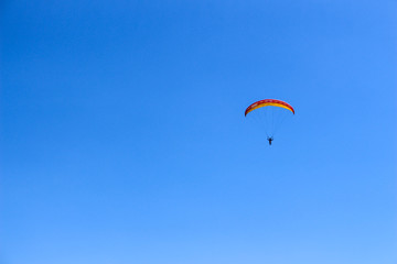 Paragliding in the blue sky on a sunny day.