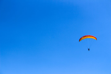 a paraglider flying in blue sky landscape in Indonesia