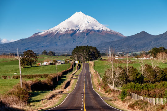 Highway heading directly to the beautiful snow capped volcanic Mount Egmont in Taranaki New Zealand