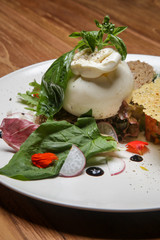 Fresh buratta cheese, toasted cereal bread with herbs and green leaf salad