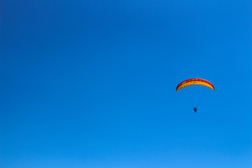 a paraglider flying in blue sky landscape in Indonesia