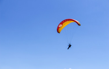 a paraglider flying in blue sky landscape in Indonesia