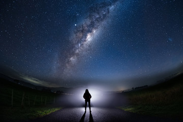 Fototapeta premium Mysterious unidentified person figure with milky way starry night sky.