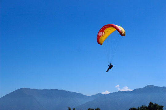 a paraglider flying in blue sky landscape in Indonesia