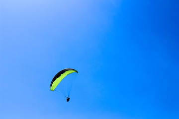 a paraglider flying in blue sky landscape in Indonesia