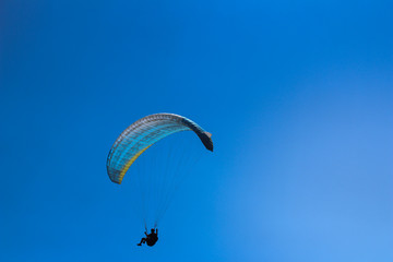 a paraglider flying in blue sky landscape in Indonesia
