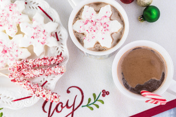 Mugs of hot chocolate and variety of toppings for hot chocolate.