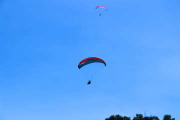 a paraglider flying in blue sky landscape in Indonesia