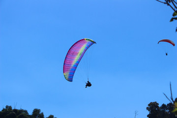 a paraglider flying in blue sky landscape in Indonesia
