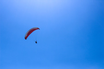 a paraglider flying in blue sky landscape in Indonesia
