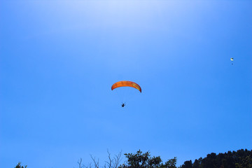 a paraglider flying in blue sky landscape in Indonesia