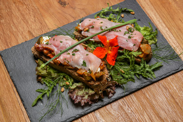 Open faced sandwich, Toasted cereal bread with ham, cheese, herbs and green leaf salad
