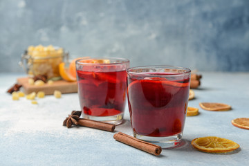Glasses of tasty mulled wine on color background