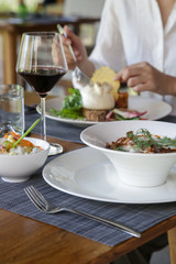 Beautifully decorated meals and a glasseof red wine on the wooden table