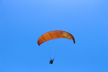 a paraglider flying in blue sky landscape in Indonesia