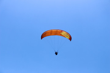 a paraglider flying in blue sky landscape in Indonesia