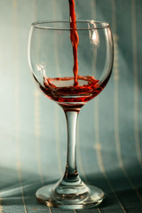 Red juice being poured on a wine glass