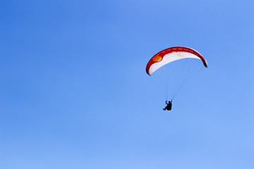 paraglider flying in blue sky on valleys landscape in Indonesia