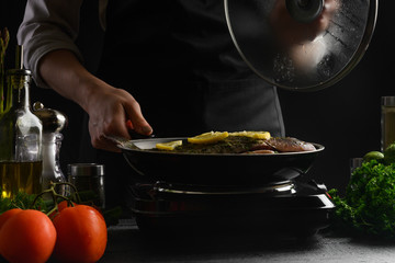 Japanese or Oriental cuisine, Seafood, Chef cooks fish, frying in a pan. with ingredients on the table. Healthy and healthy food, sale of seafood, fish shops. Horizontal shot.