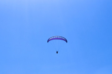 a paraglider flying in blue sky landscape in Indonesia