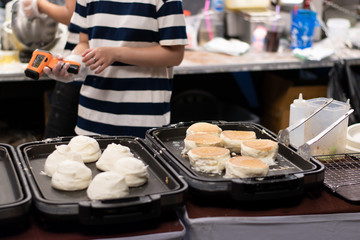 Employees are making thick, fluffy pancakes on the pan.