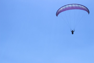 a paraglider flying in blue sky landscape in Indonesia