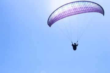 a paraglider flying in blue sky landscape in Indonesia
