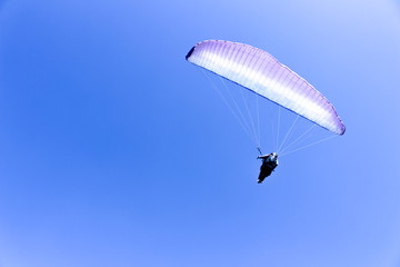 paraglider flying in blue sky on valleys landscape in Indonesia