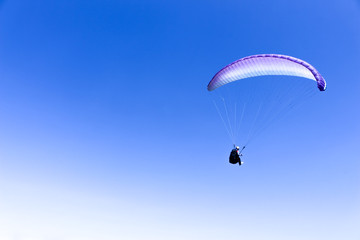 paraglider flying in blue sky on valleys landscape in Indonesia