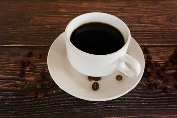 cup of coffee and beans on wooden table