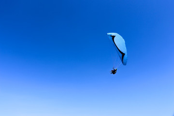 paraglider flying in blue sky on valleys landscape in Indonesia