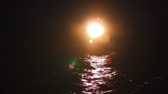 Offshore crewboat during night crewchange on offshore oilfield. FPSO tanker vessel near Oil platform Rig. Offshore oil and gas industry, sea oil production and storage