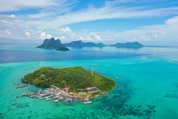 Aerial view of the Selakan island with crystal clear water, blue sky and mountain background in Semporna, Sabah, Malaysia.